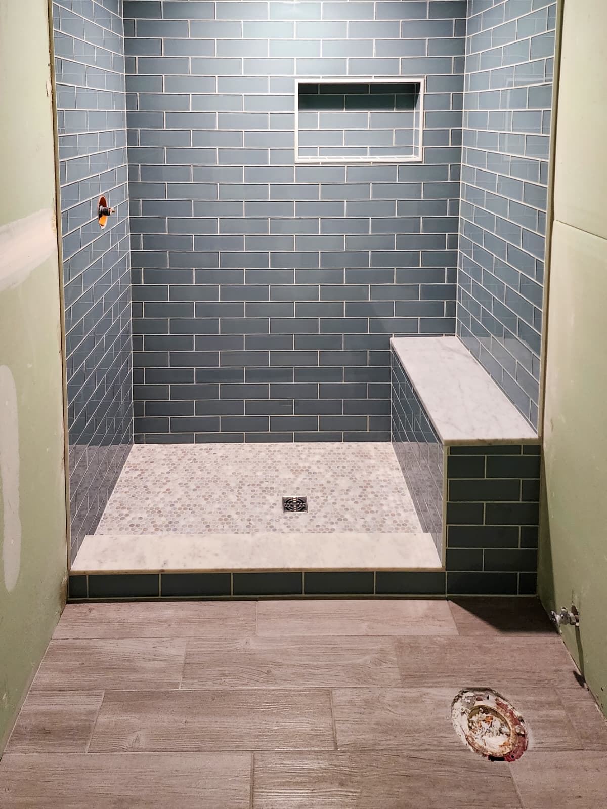 Custom tiled shower with built-in bench and recessed niche