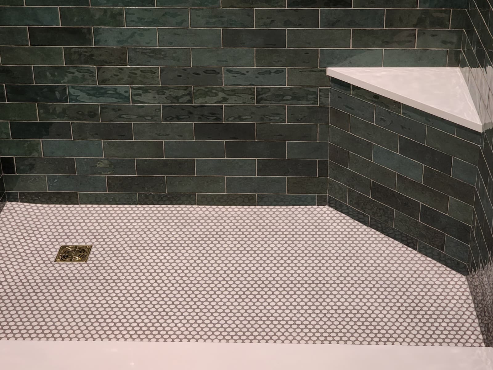 White subway tile shower with niche and pebble floor