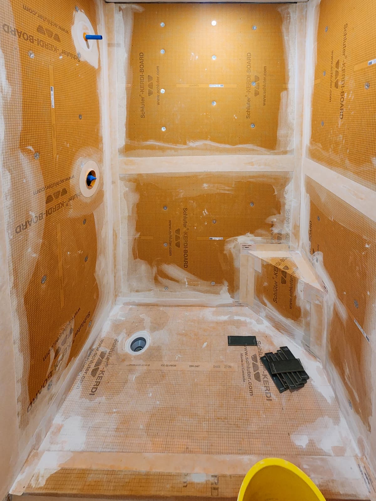 Shower waterproofing membrane installed on walls, bench and floor before tile