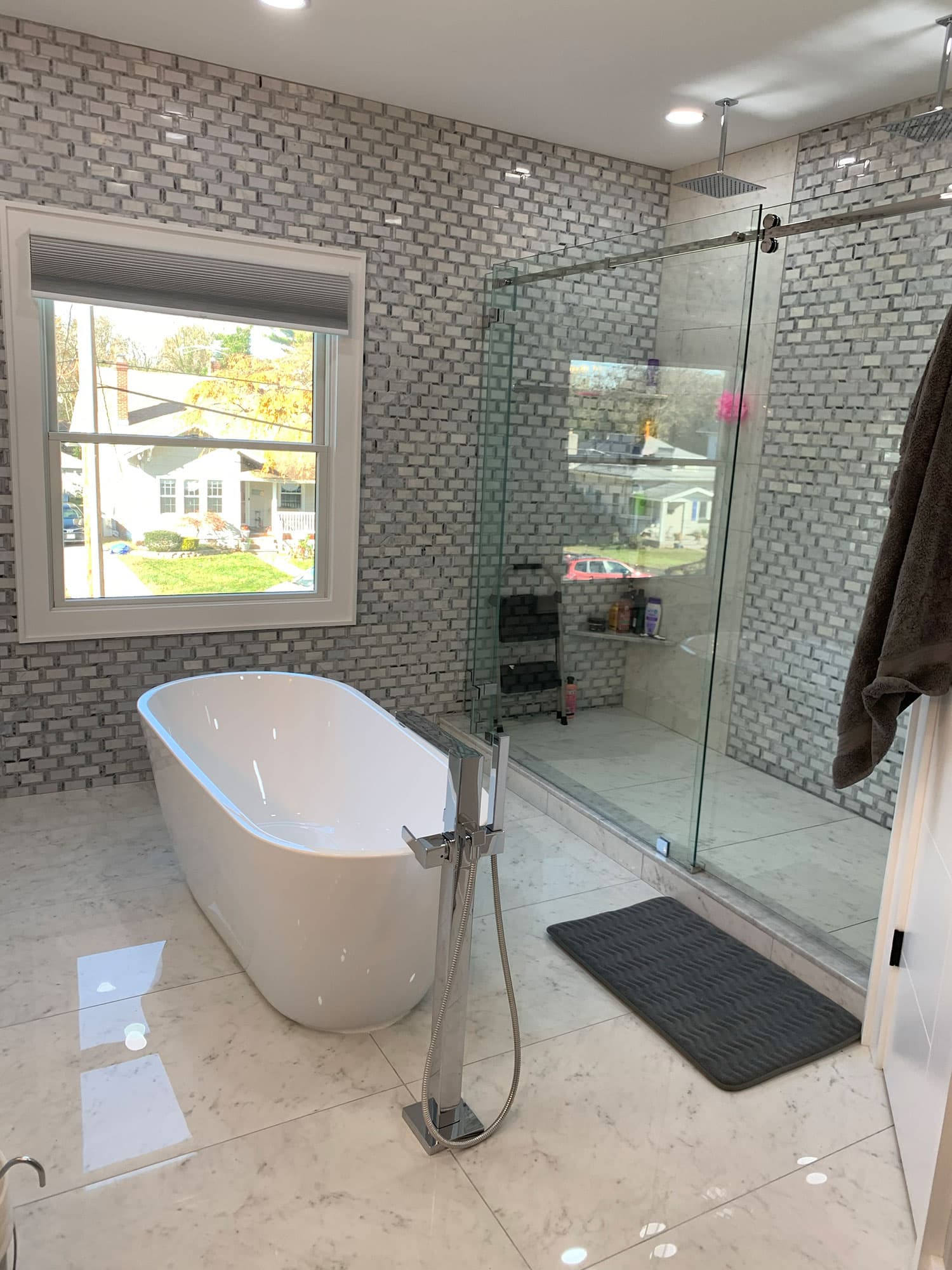 Finished bathroom with freestanding tub, shower glass and tile walls